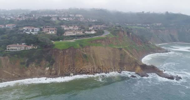 Luchtfoto vliegen in herenhuizen naast Cliff: kust rotsachtige strand in Palos Verdes, Californië, mistige dag — Stockvideo