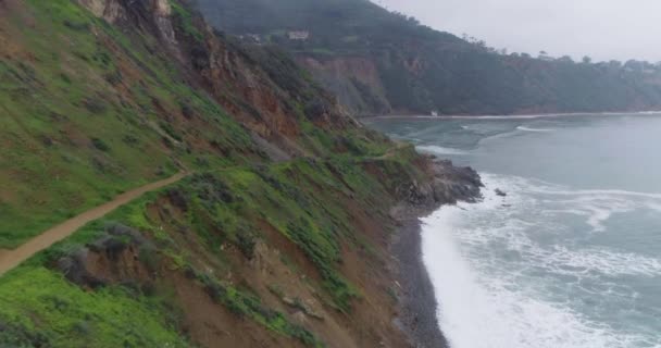 Aerial flyve fremad ved Cliff: Kyst Stenet strand Snavs Trail, tåget dag – Stock-video