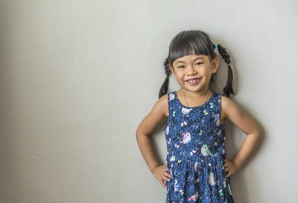 Entzückend glücklich asiatische kleines Mädchen lächelt über grauen Hintergrund — Stockfoto