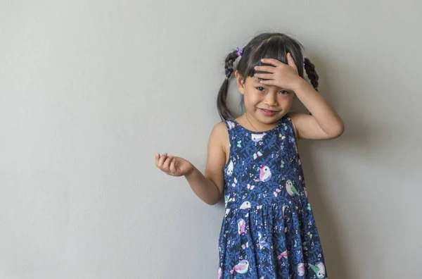 Bezaubernde lustige asiatische kleines Mädchen lächelt über grauen Hintergrund — Stockfoto