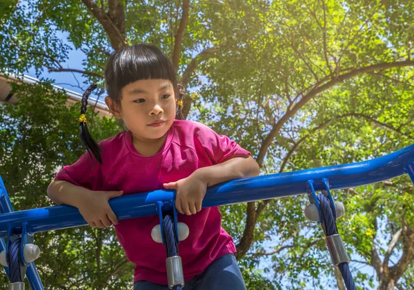 Gelukkig klein meisje klimmen op outdoor speeltuin — Stockfoto