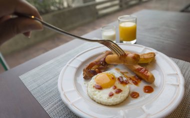 Kahvaltı yemek sosis çatal bıçak kullanarak el