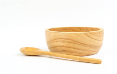 İzole edilmiş küçük bir kase ve beyaz arka planda kaşık. Kasenin önü, kaşık kasenin önüne. Sağlıklı için ahşap mutfak gereçleri