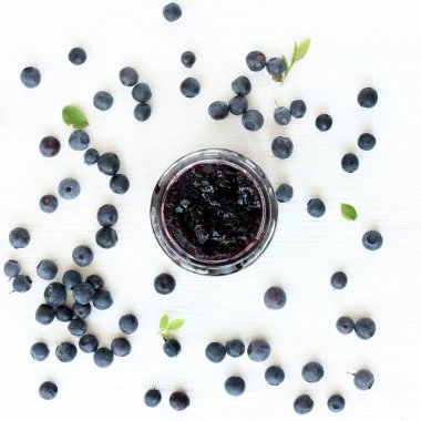 Açık berry reçel kavanoz taze çilek ile dekore edilmiş ve orman yaban mersini üstten görünüm bırakır