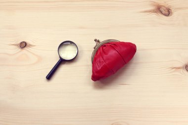 kırmızı çanta ve büyüteç düz tahta yüzey üzerinde yatar üst görünüm / arama ve yatırımların depolanması