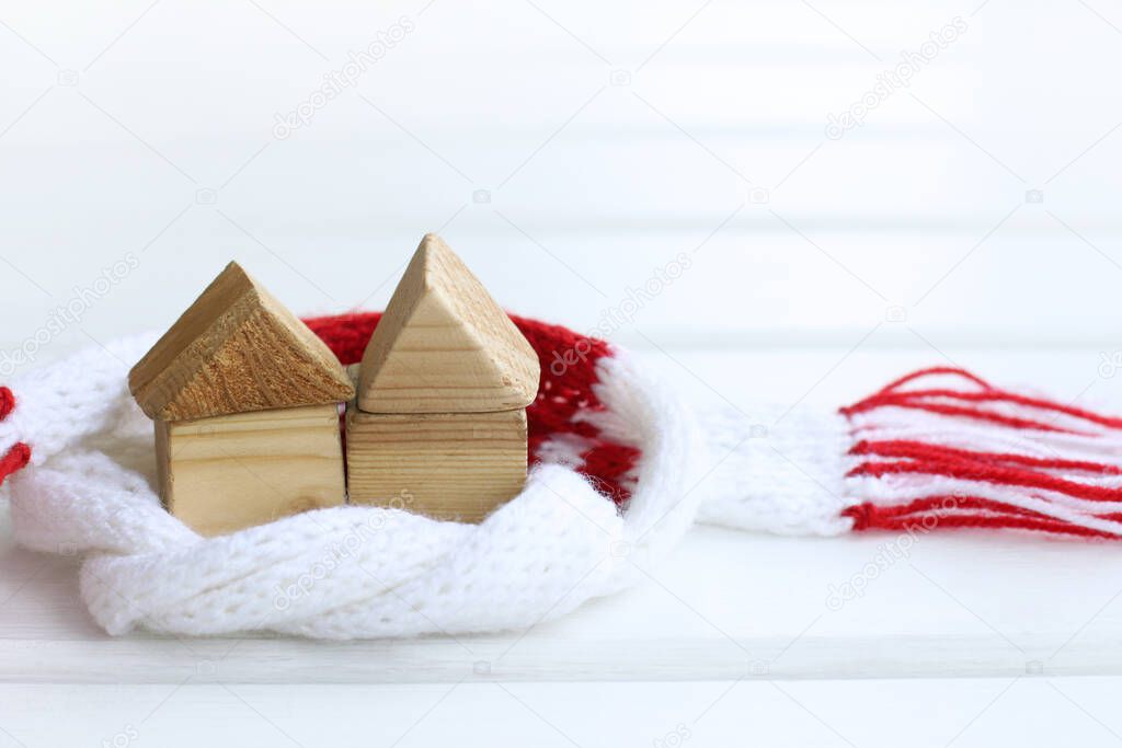 models of wooden houses in a scarf on the table front view / double warming effect