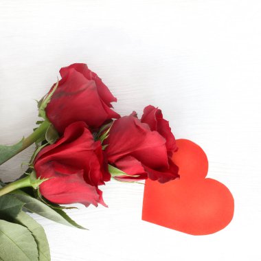 Işık yüzeyinde üç kırmızı gül ve kalp sembolü Romantik bir buluşmaya davetiye