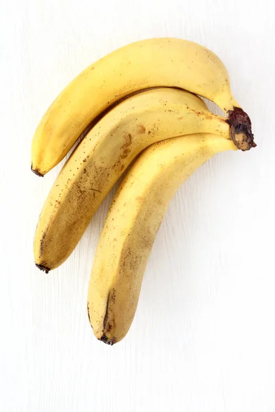 Tři Zralé Banány Lehkém Dřevěném Povrchu Svazek Žlutého Ovoce — Stock fotografie