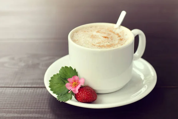 赤い熟したベリーの花と葉の横に泡立つカプチーノのカップシナモン ストロベリーコーヒーを振りかけた気分で一時停止 — ストック写真