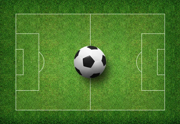 Futbol topu futbol alanının yeşil çimenlerin üzerinde.