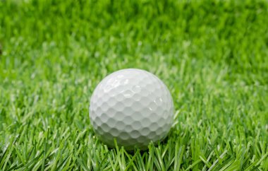 Yeşil çimlerin üzerinde golf topu.