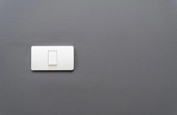 Light switch on gray concrete wall background.