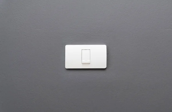 Light switch on gray concrete wall background.