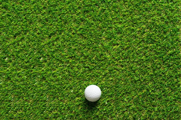 Golf topu golf sahası arka plan için yeşil çim dokusu üzerinde.