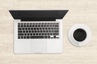 Laptop ve ahşap masada bir fincan kahve. Üst görünüm işi için 