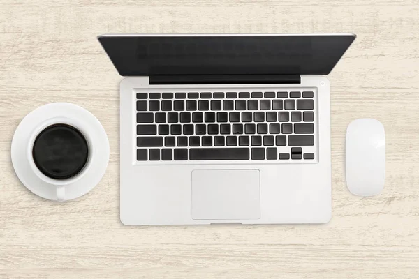 Ordenador portátil y una taza de café en la mesa de madera . — Foto de Stock