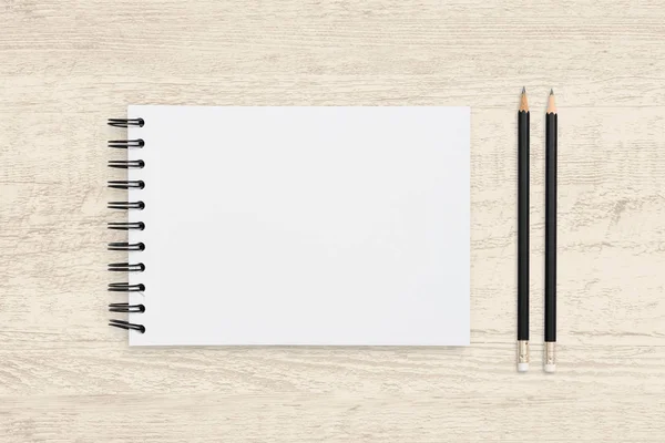 Bovenaanzicht object achtergrond van blanco notebook en potlood op woode — Stockfoto