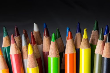 Mevsimlik koyu arka plan üzerinde renkli kalem demet