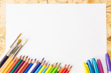 Renkli kalemler, işaretleri ve Boya fırçaları, boş kağıt, ahşap yüzeyi üzerine demet