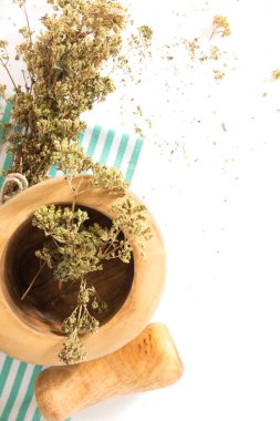 Buket harcı ve havaneli, beyaz arka plan üzerinde katlanmış bez havlu üzerinde kuru kekik.