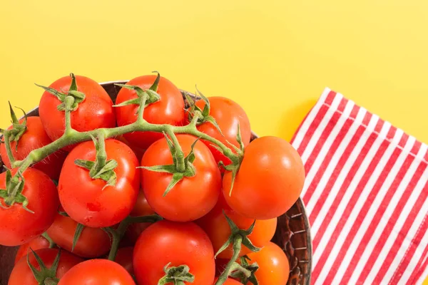 Tomates rojos cereza con tallo en tazón metálico antiguo, sobre fondo amarillo vivo — Foto de Stock