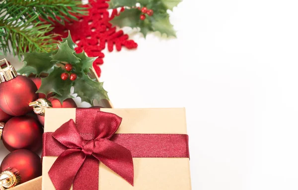 Geschenkbox aus Papier mit roter Schleife und Weihnachtskugeln, auf weißem Hintergrund. — Stockfoto