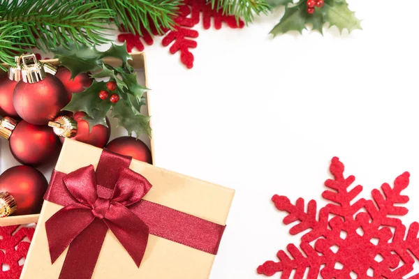 Scatola regalo di carta con fiocco rosso e palline di Natale, su sfondo bianco . — Foto Stock
