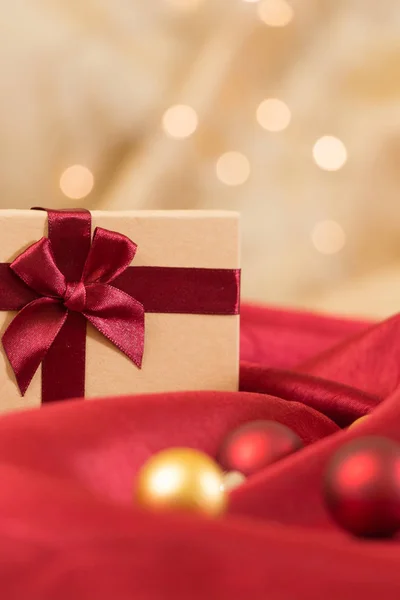 선물 상자 크리스마스 볼 물결 모양의 빨간색 새틴 직물에 활. 스톡 이미지