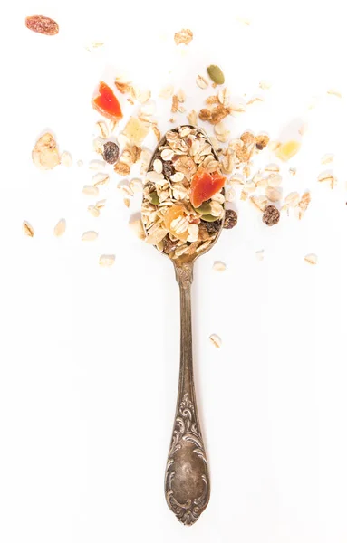 Lepel met muesli en droge vruchten, op witte achtergrond. Stockfoto