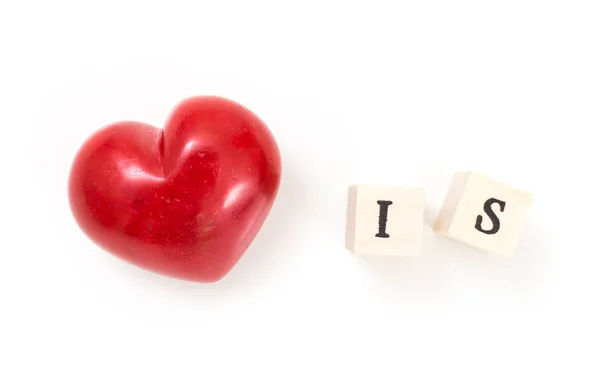 Red heart and wooden cubes with word Is, on white background. Love is concept. — Stock Photo, Image