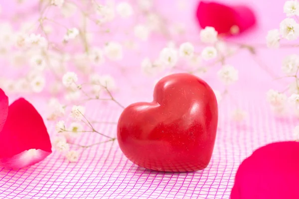 Gros plan de coeur rouge et fleurs blanches, sur maille rose . — Photo