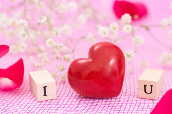 Červené srdce a bílé květy a dřevěné kostky s písmeny I a U. Miluji tě koncepce. — Stock fotografie