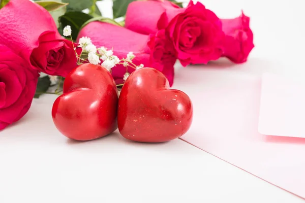 Deux cœurs rouges avec enveloppe rose et roses rouges gros plan . — Photo