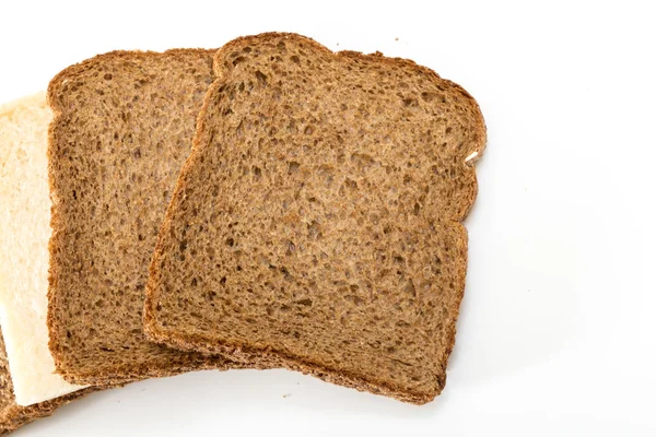 Whole grain sandwich bread slices with one white slice, on white background. — Stock Photo, Image