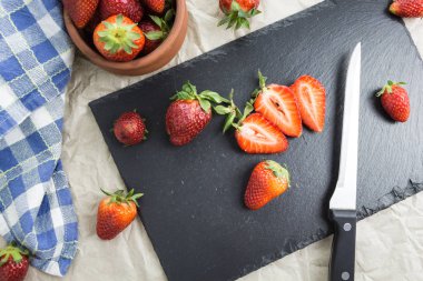 Bir tablo bazı dilimlenmiş ve bıçak kırmızı olgun çilek