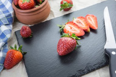 Bir tablo bazı dilimlenmiş ve bıçak kırmızı olgun çilek.