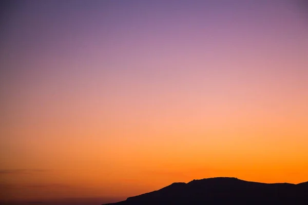 Schöne lebendige und bunte Sonnenaufgang / Sonnenuntergang Hintergrund mit dunklen Silhouetten der Berge. — Stockfoto