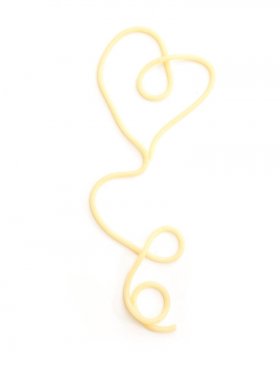 Beyaz arka plan üzerinde düz pişmiş spagetti makarna şeklinde kalp.