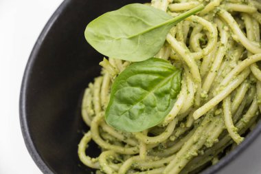 Spagetti makarna sosu pesto siyah kase, closeup arka plan ile.