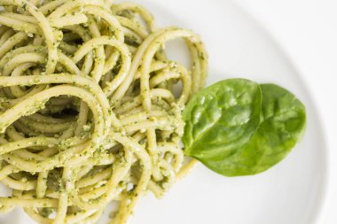 Spagetti makarna ile pesto sos beyaz tabak, closeup beyaz arka plan üzerinde.