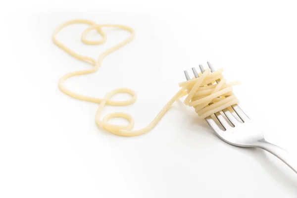 Massa de espaguete cozida lisa em garfo com forma de coração, sobre fundo branco . — Fotografia de Stock