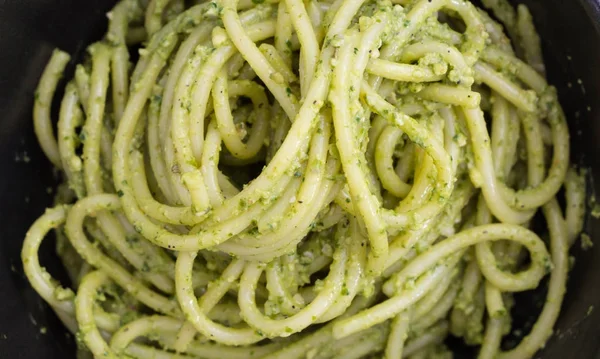 Pasta de espaguetis con pesto de salsa en tazón negro, fondo de primer plano . — Foto de Stock