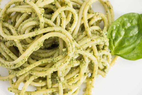 Spagetti tészta pesto szósszal fehér csészében, háttér. — Stock Fotó