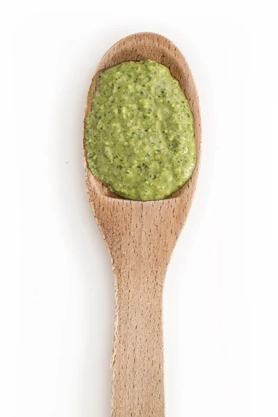 Salsa de pesto verde recién hecho en cuchara de madera, primer plano sobre fondo blanco . — Foto de Stock