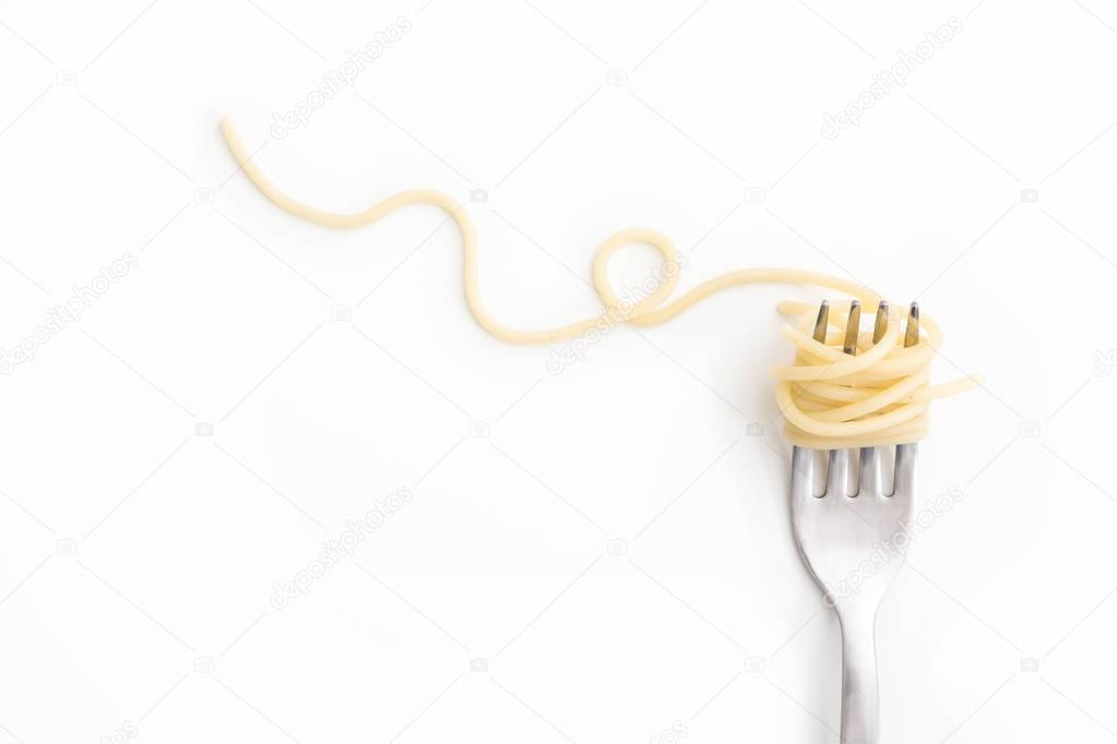Plain cooked spaghetti pasta on fork with swirl, on white background.