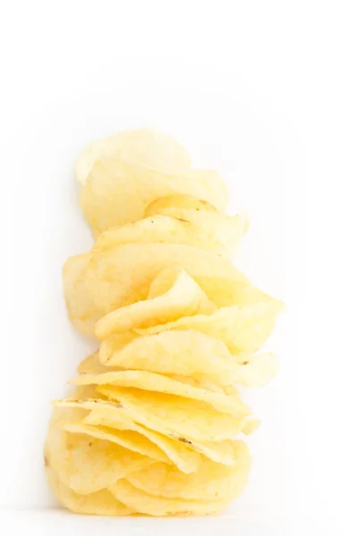 Хрустящие тонко нарезанные картофельные чипсы на белом фоне . — стоковое фото