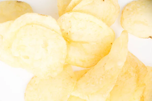 Хрустящие тонко нарезанные картофельные чипсы крупным планом, на белом фоне . — стоковое фото