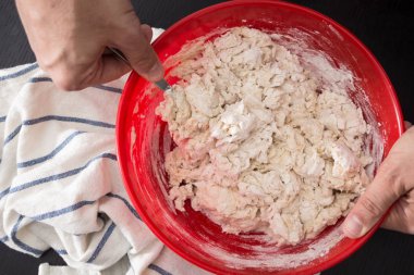 Erkek yapma / kırmızı kapta hamur karıştırma eller hazırlık closeup pişirme.