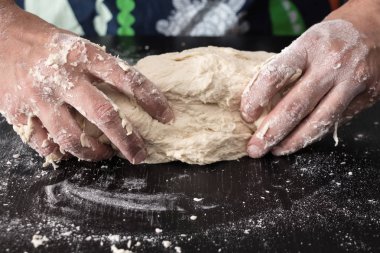 Erkek hazırlık closeup pişirme yoğurma hamur, eller.