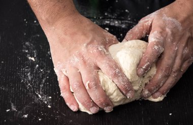 Erkek hazırlık closeup pişirme yoğurma hamur, eller.